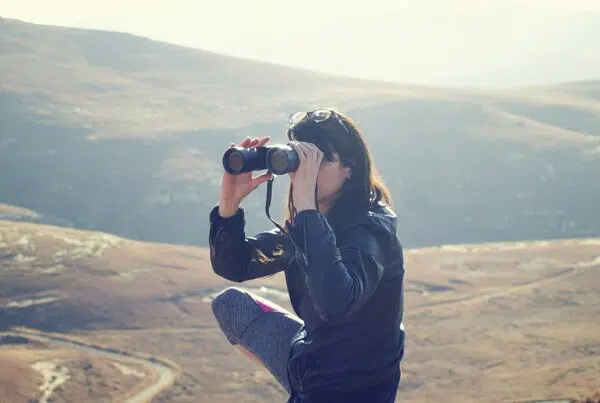 woman on a mountain with binoculars